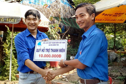 Thái Vĩnh Bảo (bên phải) trao tặng hỗ trợ mô hình kinh tế cho thanh niên